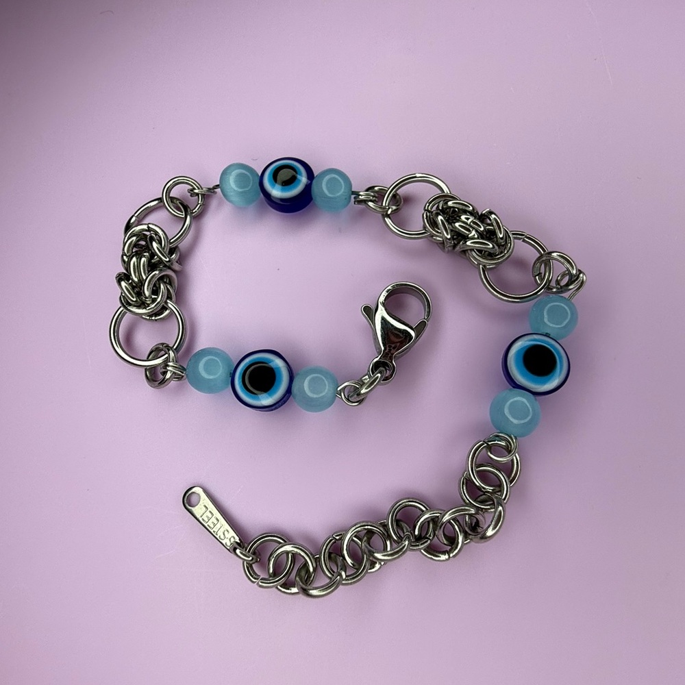 silver steel bracelet with blue evil eye beads and selenite crystal